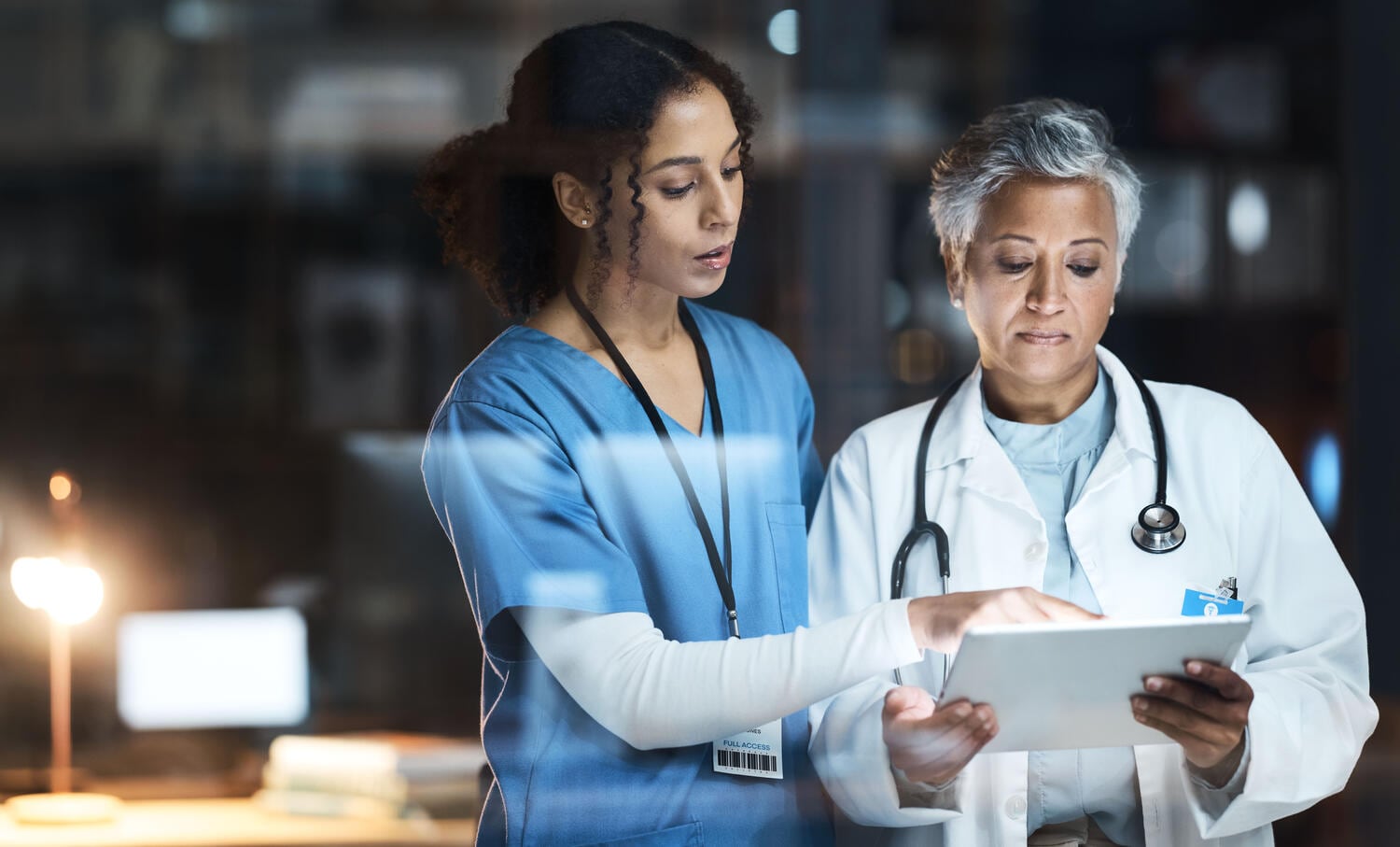 Doctor and nurse using tablet to analyze data