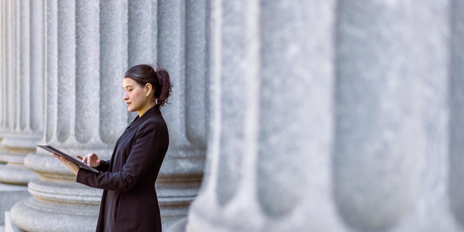 AI in Public Sector Female lawyer using tablet in front of court house