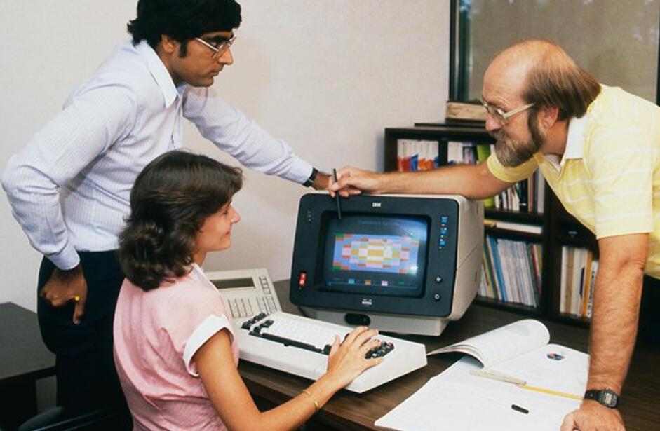 SAS employees using an old IBM computer in the 1970s